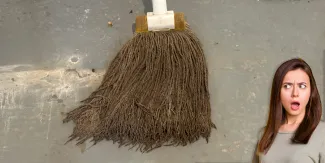 Woman's shocked face as she looks at a dirty, disgusting string mop.